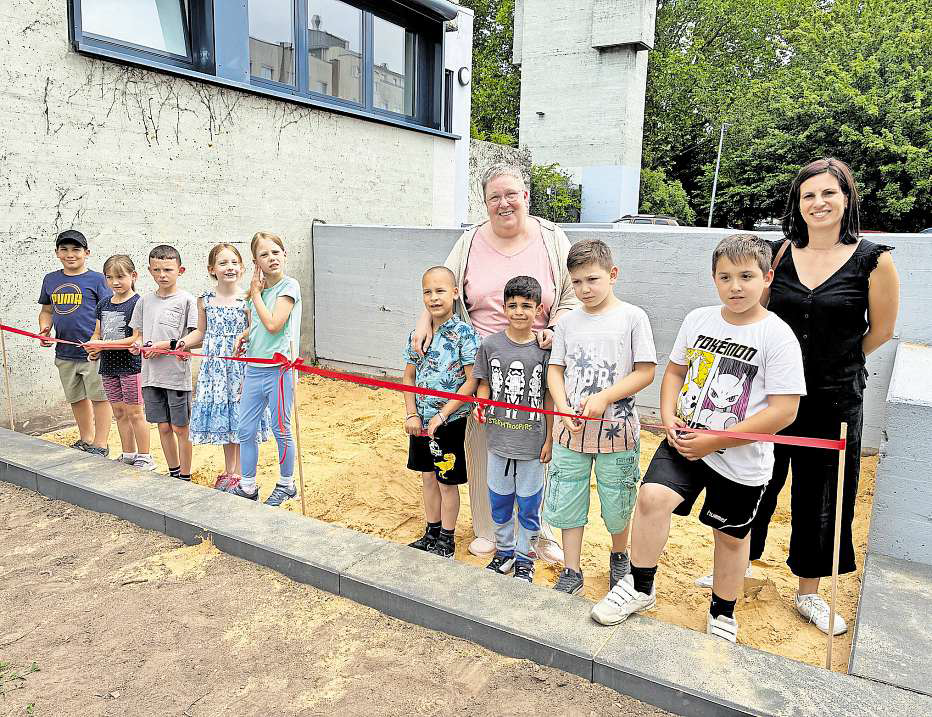 Die Kinder eröffnen offiziell den neuen Sandkasten bei der Therapeutischen Schülerhilfe in Saarlouis. Hinten stehen die Leiterin Annette Berrahma (links) und Sandra Weiß, Bereichsleitung Einrichtungen bei der Caritas Saar-Hochwald. FOTO: NICOLE BASTONG